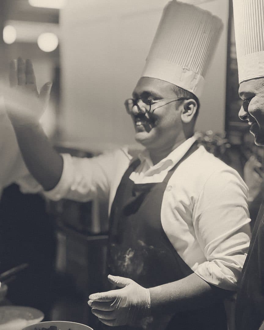 Two chefs laughing behind the counter at pizza night