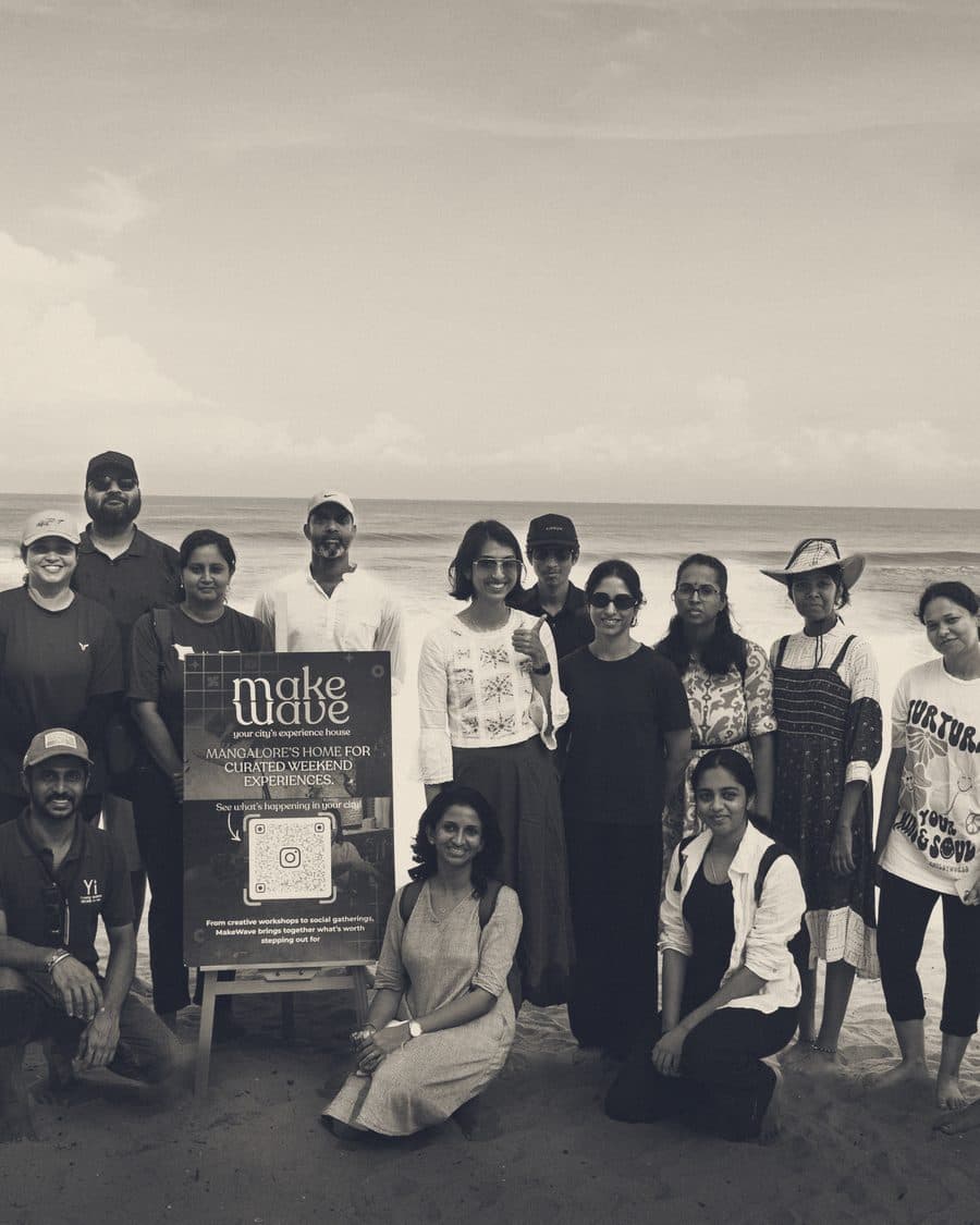 A group on the beach after the shore walk, holding the MakeWave sign