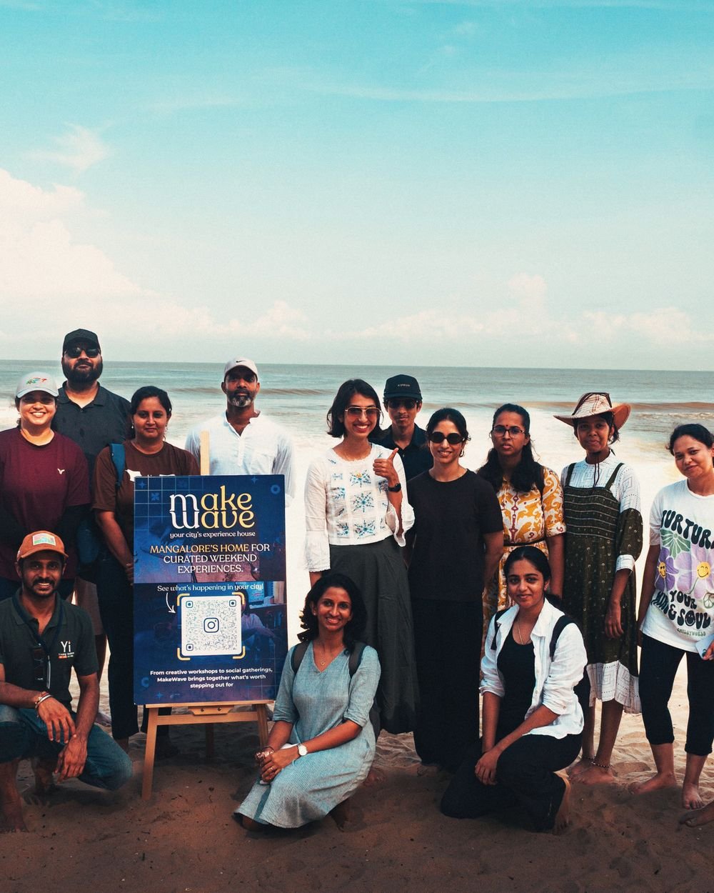 The shore walk group on the beach beside the MakeWave sign