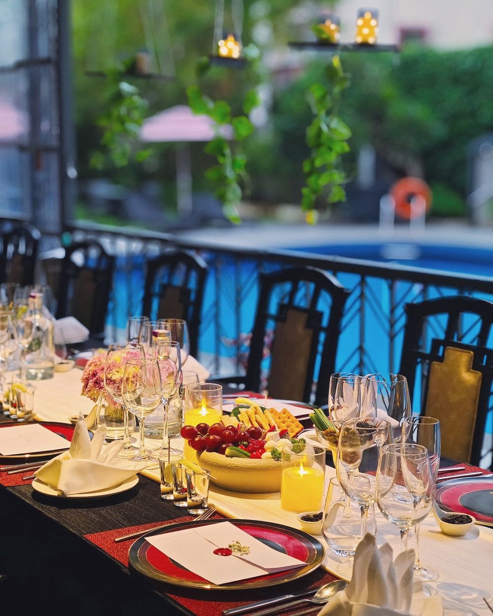 A long table set by the pool for the wine tasting, candles lit